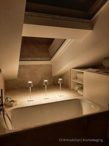 La salle de bains est pourvue d'une grande baignoire et de 2 lampes. dans l'établissement Designerloft See, à Immenstaad am Bodensee