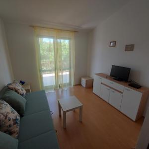 - un salon avec un canapé, une télévision et une table dans l'établissement Apartments Krešo, à Starigrad-Paklenica