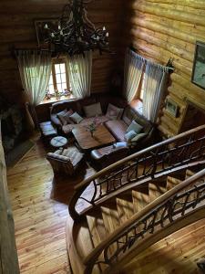 una sala de estar con sofá y una escalera en una cabaña en Lisotel, en Rokytne