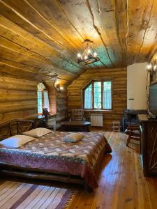 a bedroom with a large bed in a log cabin at Lisotel in Rokytne