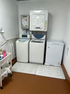 a laundry room with two refrigerators and a microwave at Sakurahome&El Flamenquito in Muroto