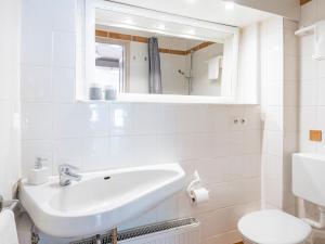 a white bathroom with a sink and a toilet at Lieblingsort Lachen in Timmendorfer Strand