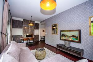 a living room with a couch and a table at InPoint 2-bedrooms Apartment with private garden and free parking in Krakow