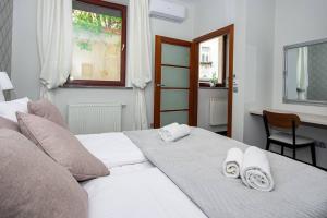 a bedroom with a white bed with towels on it at InPoint 2-bedrooms Apartment with private garden and free parking in Krakow