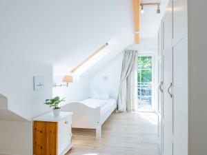 a white room with a bed and a window at Lieblingsort Freude in Timmendorfer Strand