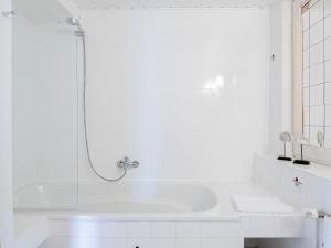 a white bathroom with a shower and a sink at Lieblingsort Freude in Timmendorfer Strand +20 photos
