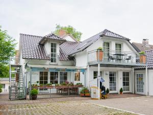 a white house with a balcony and a table at Lieblingsort Freude in Timmendorfer Strand