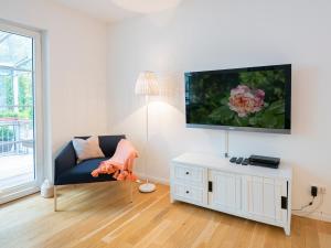 uma sala de estar com um sofá e uma televisão de ecrã plano em Lieblingsort fröhlichkeit em Timmendorfer Strand