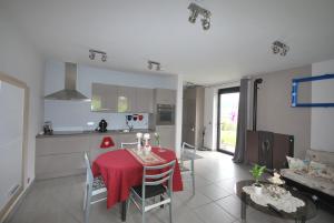 a kitchen and dining room with a red table and chairs at Nuits étoilées in Vencimont