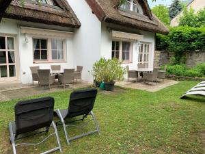 een tuin met stoelen en een tafel voor een huis bij Terézia Vendégház in Tihany