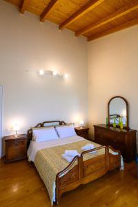 a bedroom with a bed with two night stands and a mirror at Kalamata Panorama Villa in Kalamata