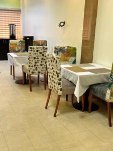 um grupo de mesas e cadeiras numa sala em Whitehouse Msquare Hotel em Ikeja