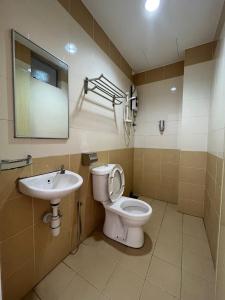 ein Bad mit einem WC und einem Waschbecken in der Unterkunft Joyful Motel in Kuah