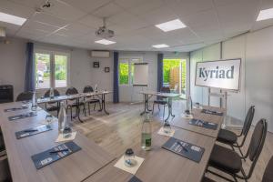 a conference room with tables and chairs and a chalkboard at Kyriad Lyon Est - Bron Eurexpo Le Cottage in Bron