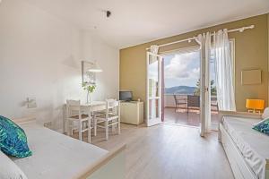 un soggiorno con letto e una sala da pranzo con tavolo di Apartments La Turistica a Capoliveri