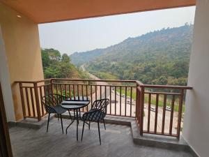 a balcony with a table and chairs and a view at Dansavanh Namngum Resort in Ban Keun