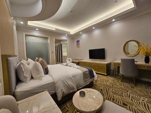 a hotel room with a bed and a desk and a television at Dansavanh Namngum Resort in Ban Keun