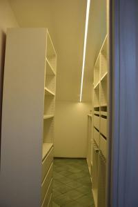 um armário vazio com prateleiras brancas num quarto em Casa Silvana em Piano di Sorrento