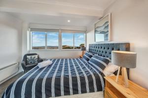 1 dormitorio con 1 cama, 1 silla y 1 ventana en The Penthouse @ Alpine Haven en Mount Hotham