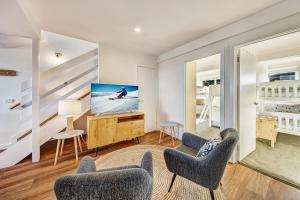 a living room with chairs and a tv on a dresser at The Penthouse @ Alpine Haven in Mount Hotham