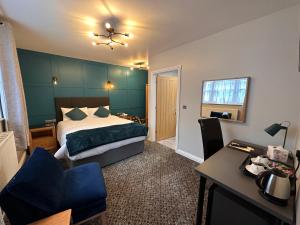 Habitación de hotel con cama, escritorio y silla en Spilman Hotel, en Carmarthen