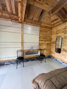 uma casa de banho com um lavatório num quarto com paredes de madeira em Ulina Homestay VIP Berastagi em Berastagi