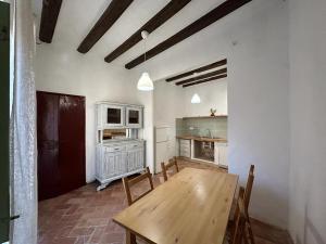 cocina con mesa de madera y sillas en una habitación en Can Pacoli, en Rupià