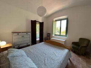 1 dormitorio con cama, silla y vestidor en Can Pacoli, en Rupià