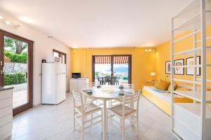 cocina y comedor con mesa y sillas en Apartments La Turistica, en Capoliveri