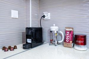 a kitchen counter with a coffee maker and a coffeemaker at Family Apartment near Port in Piraeus