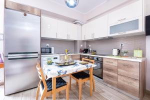a kitchen with a table with chairs and a refrigerator at Family Apartment near Port in Piraeus