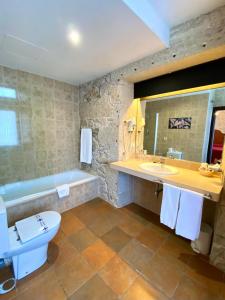 ein Badezimmer mit Toilette, Waschbecken und Badewanne in der Unterkunft Hotel Pazo de Lestrove by Pousadas de Compostela in Padrón + 37 Fotos