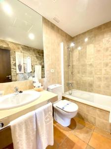 ein Badezimmer mit Toilette, Waschbecken und Badewanne in der Unterkunft Hotel Pazo de Lestrove by Pousadas de Compostela in Padrón