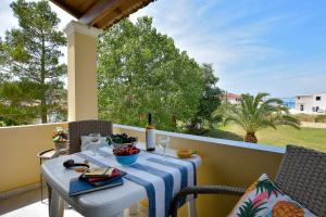 a table with a blue and white table cloth on a balcony at Eleonora Sidari Beach House in Sidari +28 photos