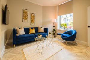 a living room with a blue couch and a blue chair at West End Retreat - SJA Stays in Aberdeen
