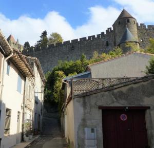an alley with a castle in the background at Maison des Remparts nichée sous la Cité in Carcassonne