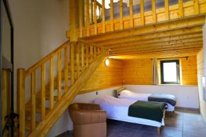 a bedroom with two beds and a staircase at Le Domaine d'Arignac - La grande maison in Arignac
