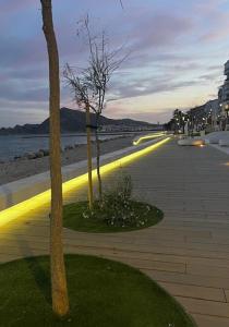 a sidewalk with trees and lights on the beach at Casa Violeta in Altea