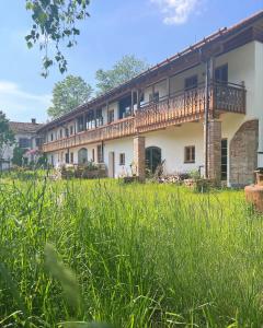 eine Außenansicht eines Gebäudes mit hoher Wiese in der Unterkunft Sunhill Appartments in Winhöring