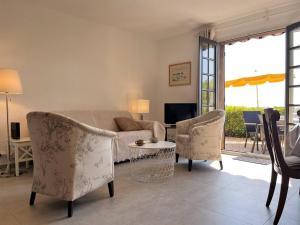 uma sala de estar com um sofá, cadeiras e uma mesa em Maison Le Lavandou, 3 pièces, 6 personnes - FR-1-251-502 em Le Lavandou