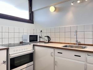 een keuken met een wastafel en een magnetron bij One Bedroom Apartment In Rdovre, Trnvej 29b, in Rødovre