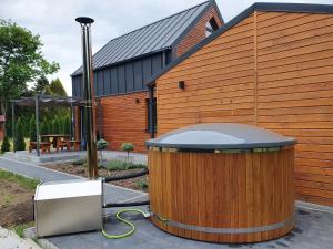 Domek na Polanie في أوسترون: حوض خشبي كبير جالس بجوار مبنى