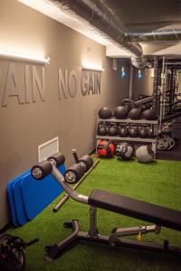 une salle de sport avec des haltères et un panneau sans gain sur le mur dans l'établissement MASA Hotel & Spa Campo Grande Collection, à Lisbonne