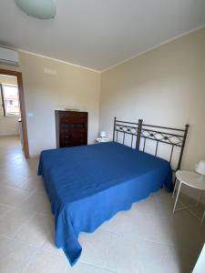 una camera con un letto blu e un tavolo di Villetta Paestum a Mattine