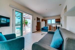 a living room with a couch and a kitchen at Summer Breeze - Cheerful 2 bedroom villa with pool in Ayia Napa