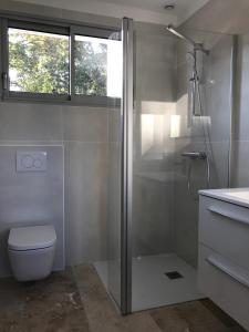 Un baño con ducha, inodoro y ventana. en Vue Superbe sur Tour de la Lanterne T2 avec Terrasse Remparts 2, en La Rochelle