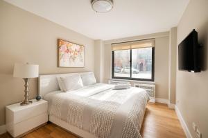 een witte slaapkamer met een bed en een raam bij 3 BR in Upper West Side in New York