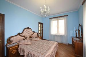 a blue bedroom with a bed and a chandelier at Homestay at City Center in Yerevan