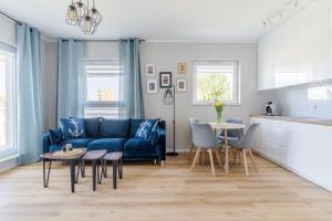- un salon avec un canapé bleu et une table dans l'établissement Hallera by Loft Apartments, à Gdańsk