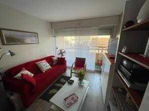 - un salon avec un canapé rouge et une table dans l'établissement Appartement Capbreton, 2 pièces, 2 personnes - FR-1-413-216, à Capbreton